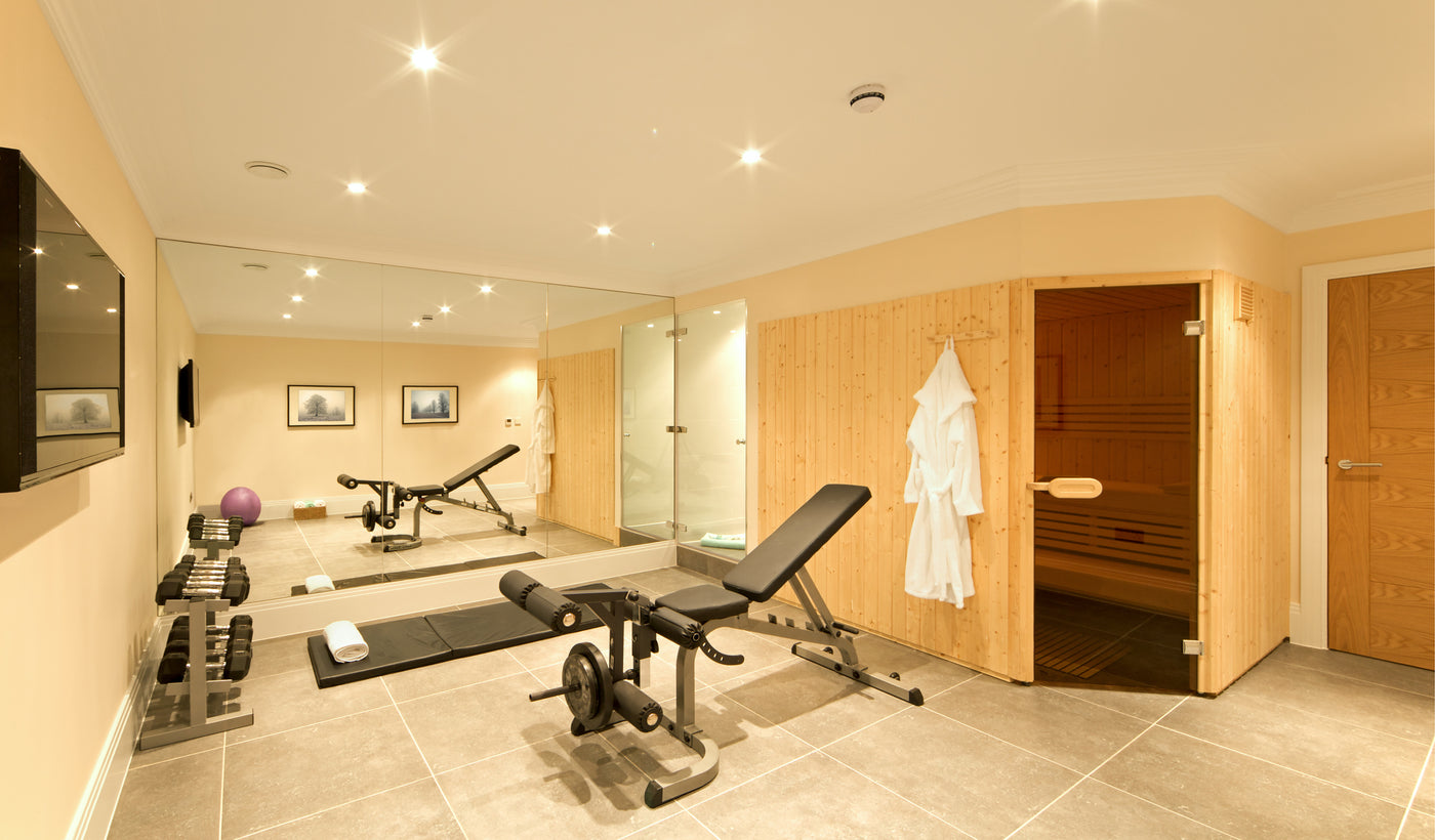 A sauna with a home gym surrounding it